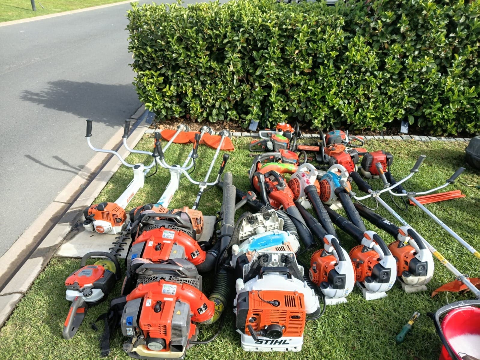 The 2Green garden maintenance equipment fleet: brushcutters, hedge trimmers, blowers and chainsaws laid out at a Paarl estate